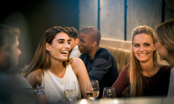 Two young attractive women having fun over a drink at a wine bar