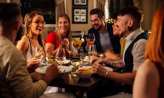 Group of young adults having a good time eating out at a restauraunt
